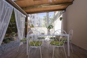 uma sala de jantar com uma mesa e cadeiras numa varanda em Apartment with garden and free parking em Pula