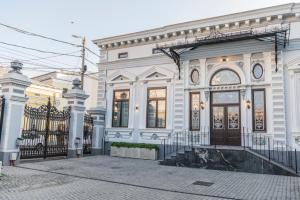 una casa blanca con una puerta y un edificio en SIR LUXURY BOUTIQUE HOTEL en Brăila