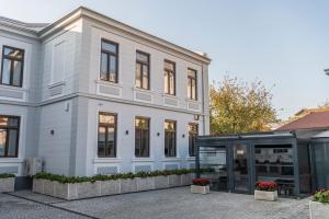 a white building with a glass door in front of it at SIR LUXURY BOUTIQUE HOTEL in Brăila