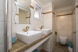 a bathroom with two sinks and a toilet at Apartment with garden and free parking in Pula