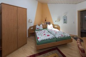 1 dormitorio con 1 cama y armario de madera en Gästehaus Schmitt, en Appenheim