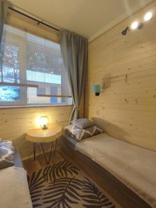 a room with two beds and a table and a window at Połoninka in Ustrzyki Górne