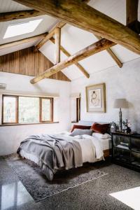 um quarto com uma cama grande num quarto com tectos em madeira em Luxury Yarra Valley Vineyard Log Cabin em Yellingbo