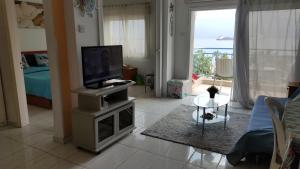 ein Wohnzimmer mit einem TV, einem Sofa und einem Tisch in der Unterkunft Sea Front & City Center, Amazing Sea View in Limassol