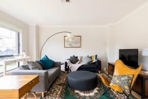 uma sala de estar com um sofá e uma mesa em 28 BOWLING AVE POINT COOK em Point Cook