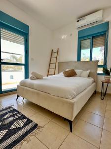 a large bed in a bedroom with blue accents at Nirvana Maayan Baruh in Ma‘yan Barukh