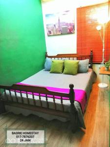 uma cama num quarto com uma parede verde em Basrie Homestay Pagoh - Private Pool/W-ifi/NetFlix/Cozy em Pagoh