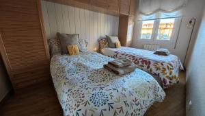 a bedroom with two beds with towels on them at ALOJAMIENTO MIRABUENOS in Aranda de Duero