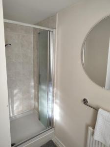 La salle de bains est pourvue d'une douche avec une porte en verre. dans l'établissement Ormonde Close 3 bed contractor family home Grantham, à Grantham