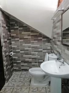 a bathroom with a toilet and a sink at Dhadas place in San Vicente