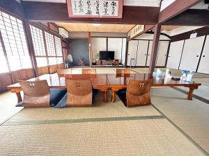 una sala da pranzo con tavolo e sedie in legno di SUN庭園 a Himeji