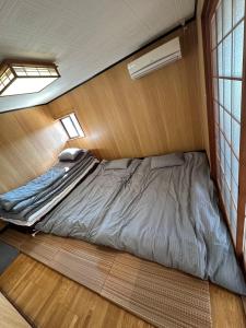 1 dormitorio con 1 cama en una habitación pequeña en SUN庭園 en Himeji