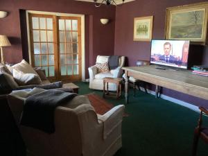 a living room with a table with a tv on it at Valley View Farm, Bed and Breakfast in Batcombe