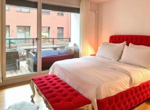 a bedroom with a red bed and a large window at La Casa - comfortable - by PA in Luzern