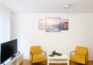 een woonkamer met 2 stoelen en een televisie bij La Casa - comfortable - by PA in Luzern