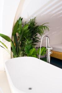 a bathroom sink with a faucet and plants at relais metis in Naples