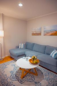 a living room with a blue couch and a table at Seewind - a15221 in Westermarkelsdorf