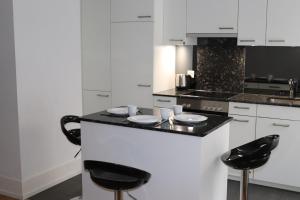 a kitchen with black and white counters and stools at La Casa - comfortable - by PA in Luzern +6 photos