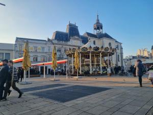 Un groupe de personnes marchant devant un carrousel dans l'établissement Sweet Nina Jazz- Appartement Cosy de 70 M2 Hyper Centre, au Mans