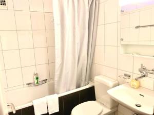 un bagno bianco con un water e un lavandino di Lucerne Apartment - near lion monument - by PAF a Lucerna