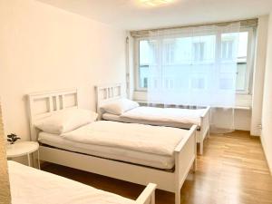 due letti in una stanza con finestra di Lucerne Apartment - near lion monument - by PAF a Lucerna