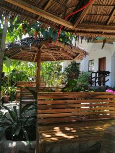 a patio with a wooden bench and a umbrella at Dhadas place in San Vicente