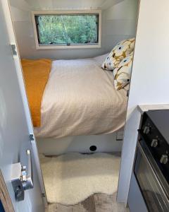 a bed in a small room with a window at Hall Farm Hideaway in King's Lynn