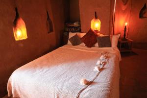a bedroom with a bed with two stuffed animals on it at Kasbah Tebi in Aït Ben Haddou