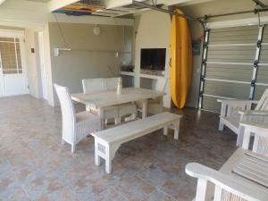 a dining room with a table and chairs and a surfboard at No 1 @ The Dunes in Plettenberg Bay