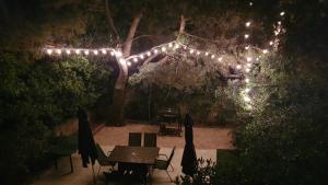 a patio with a table and a tree with lights at Holiday Home Darko in Novalja