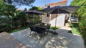 a patio with a table and two umbrellas at Holiday Home Darko in Novalja