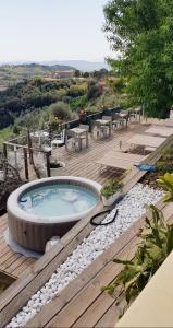 a hot tub sitting on top of a wooden deck at Sestosenso Suites in Campiglia Marittima