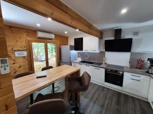 a kitchen with a wooden table and a counter top at Les Grands Frênes in Plaine-de-Walsch