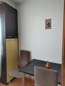 Una mesa de comedor con sillas y un refrigerador. en HMM Apartament, en Sibiu