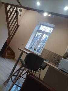 a desk and a chair in a room with a window at Chorni vivtsy in Chernivtsi