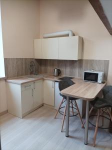 a kitchen with a table with chairs and a microwave at Chorni vivtsy in Chernivtsi