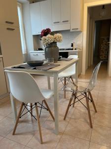 une table avec des chaises et un vase de fleurs. dans l'établissement Apartment Nicole, à Menaggio