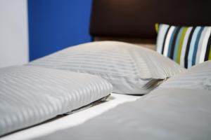 2 almohadas blancas encima de la cama en Max Lodging Serviced Apartments en Múnich