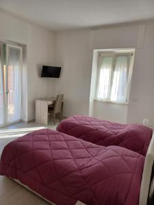 een slaapkamer met 2 paarse bedden in een kamer bij Alloggio del generale in Viterbo