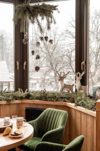 una habitación con una mesa y dos renos en una ventana en Villa Vita Krupówki, en Zakopane