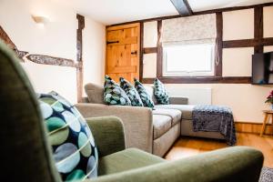 a living room with two couches and a window at Thursdays Corner Tudor Cottage in Church Stretton