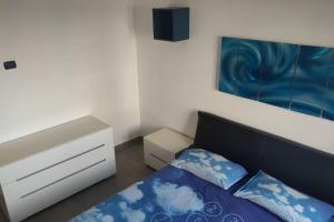a bedroom with a blue and white bed and a dresser at Barzo Apartment in Rome