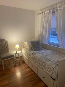 a bedroom with a bed and a chair and a window at Lux Plus apartament Chodzież, Zwycięstwa 13 in Chodzież