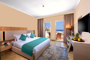 Habitación de hotel con cama y escritorio con TV. en Zen Resort Sahl Hasheesh by TBH Hotels en Hurghada