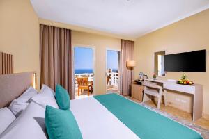a hotel room with a bed and a desk with a television at Zen Resort Sahl Hasheesh by TBH Hotels in Hurghada