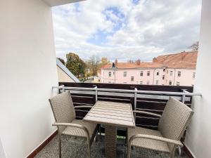 einen Tisch und Stühle auf einem Balkon mit Aussicht in der Unterkunft BetterBeds Brandenburg in Brandenburg an der Havel