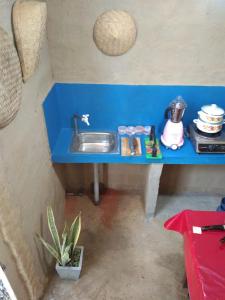 un bancone blu con lavandino in una casa giocattolo di New Cinnamon Garden a Weligama