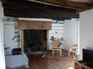 ein Wohnzimmer mit einem Kamin und einem Sofa in der Unterkunft Lou Cantou in Marnac