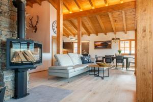 a living room with a couch and a tv at Skyberg Chalet in Mühlbach am Hochkönig