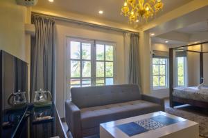 uma sala de estar com um sofá e uma grande janela em Pajaros Blu em Calangute
